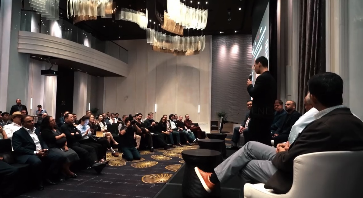 Michael Brown speaking to an audience in a ballroom